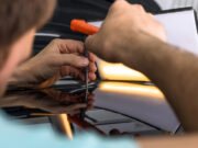 Tajomstvá PDR metódy – zaujímavé informácie o oprave preliačin na aute Technik vykonávajúci PDR opravu preliačiny na aute pomocou špeciálnych nástrojov.