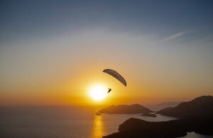 Ako prežiť leto inak? Príručka pre milovníkov dobrodružstva Skupina ľudí na letnom dobrodružstve v horách počas západu slnka.