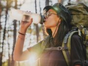 Ako si vybrať správnu fľašu na vodu do hôr? Turistická fľaša na vodu položená na skale s výhľadom na horskú krajinu