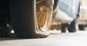 Ako jazda po výtlkoch poškodzuje pneumatiky a disky Auto prechádzajúce cez výtlk na ceste.